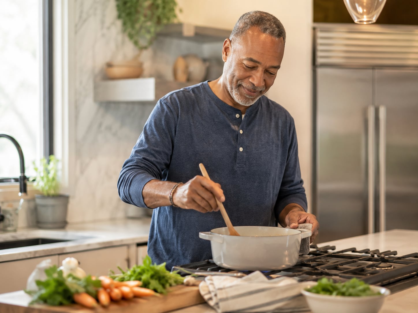 A man's hands stir food in a bowl at a kitchen counter